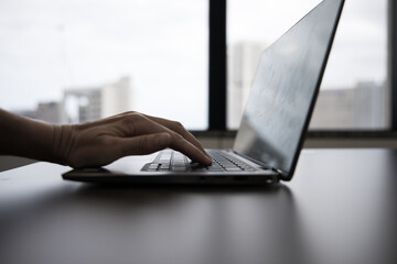 Laptop on work desk in corproate office woman typing hand