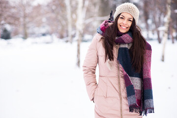 Fototapeta na wymiar Beautiful smiling young woman in wintertime outdoor. Winter concept 