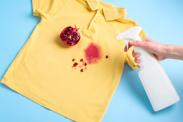 female hand holding a stain remover to remove a dirty stain from on clothes. daily life dirty stain...