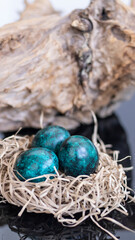 Fototapeta na wymiar Dyed eggs in dark tidewater green tones. Easter festive background, open card, eggs close-up. Table setting for the Easter holiday. Christ is Risen Easter holiday.