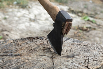 Ax on a stump. A large ax on a wooden deck. Preparation for felling wood or cutting meat.