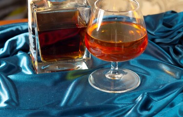 wine glass, a bottle of cognac on a colored background.