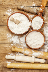 Ingredients for baking bread: bowls of flour and rolling pins