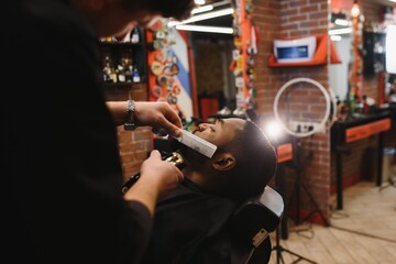 Visiting barbershop. African American man in a stylish barber shop
