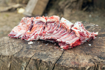 Freshly chopped meat lies on a stump.