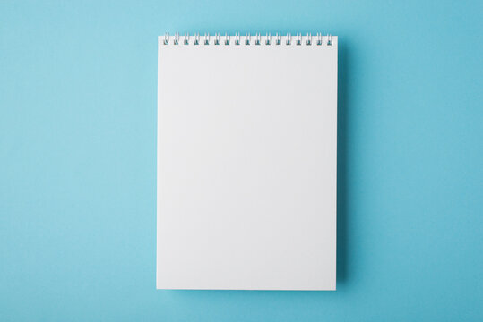 Above flat lay overhead close up view photo of clear open spiral notepad for letter document isolated light backdrop