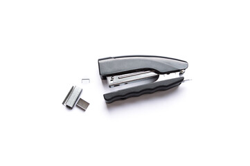 Black stapler with metal staples on white background. Office tools.