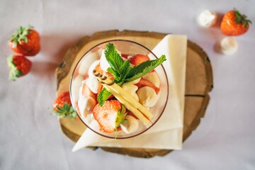 Strawberries with whipped cream decorated with fruits. Sweet dessert with apple, strawberry and  fruits