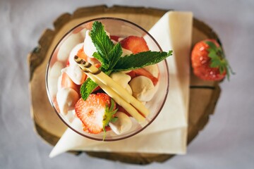 Strawberries with whipped cream decorated with fruits. Sweet dessert with apple, strawberry and  fruits