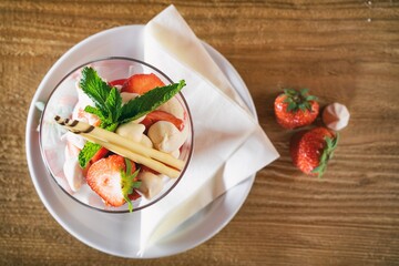 Strawberries with whipped cream decorated with fruits. Sweet dessert with apple, strawberry and  fruits