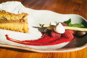 Apple pie on a plate decorated with fruits. Sweet dessert with apple, strawberry and fruits