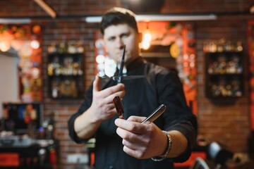 Portrait of handsome young man standing at barber shop. Stylish hairstylist standing in his salon with his arms crossed.