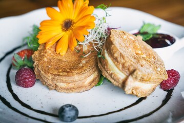 Fried Shepherd cheese with cranberry on a plante. Dinner appetizer on a wooden table. Traditional polish cuisine