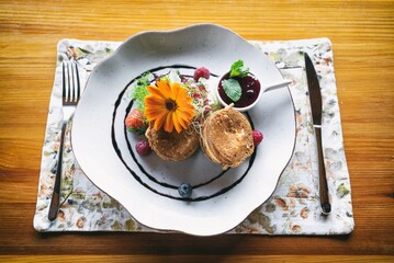 Fried Shepherd cheese with cranberry on a plante. Dinner appetizer on a wooden table. Traditional polish cuisine