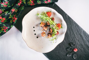 Plum in crispy bacon on a plante. Dinner appetizer on a wooden table. Traditional polish cuisine