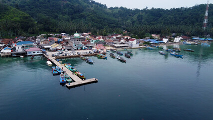 Fototapeta na wymiar Pier with at Lampung Sea Pahawang Beach, located near the Sumatera city aerial drone. Resort Pahawang With a clouds on the Sky in a day. 