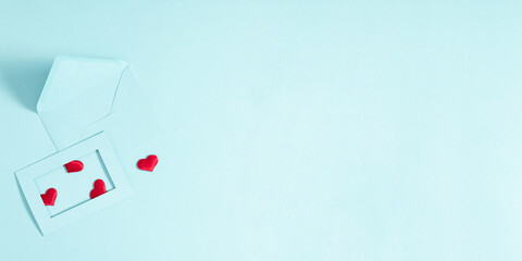 Creative minimal Valentine's Day concept. Envelopes, red hearts confetti, valentines on pastel blue background. Flat lay, top view, copy space
