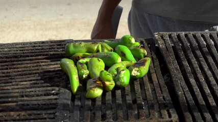 Jalapenos are grilled over charcoal. Grilled green peppers