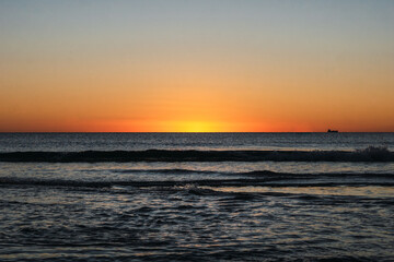 Fototapeta na wymiar Last moment of the sun setting at sunset over the sea