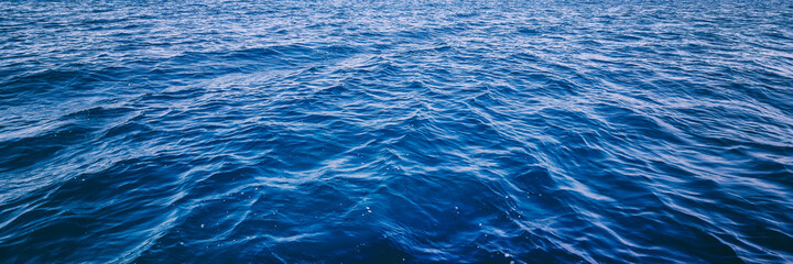 Blue deep sea ocean water in calm, banner format