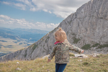 Naklejka premium Little girl running, enjoying freedom and have fun in mountains.