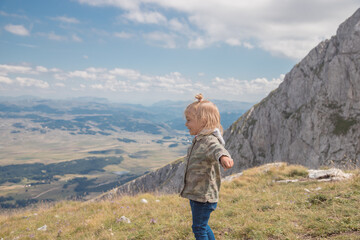 Little girl running, enjoying freedom and have fun in mountains.