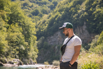 Fototapeta na wymiar Portrait of handsome stylish man on walk near riverside. Canyon Tara , Montenegro.