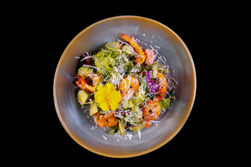 Seafood Caesar Salad with Shrimps, Salad Leaf, Croutons, Cherry Tomato and Parmesan Cheese on gray plate isolated on black background.Top view.