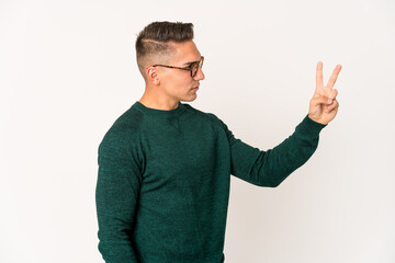 Fototapeta premium Young caucasian handsome man isolated joyful and carefree showing a peace symbol with fingers.