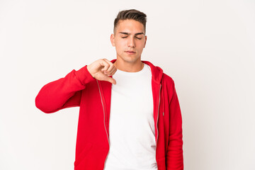 Young caucasian handsome man isolated showing a dislike gesture, thumbs down. Disagreement concept.