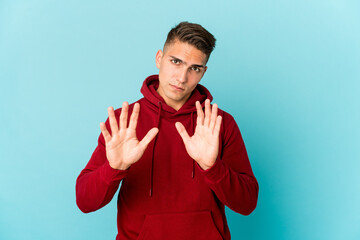 Young caucasian handsome man isolated rejecting someone showing a gesture of disgust.