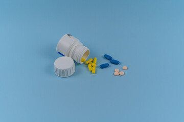 bottle with yellow and blue pills on a blue background