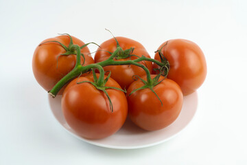 Close-up of red tomatoes on a white plate.