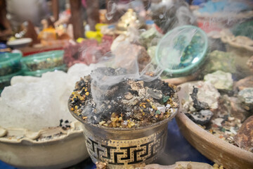 smoke comes from burning incense and around the table of different types and smells