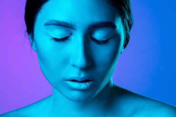 Fototapeta premium Close up. Beautiful east woman's portrait isolated on gradient studio background in neon, monochrome. Female brunette model. Concept of human emotions, facial expression, sales, ad, fashion and beauty