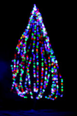 Fototapeta na wymiar Christmas tree made of decorated with colorful garlands.