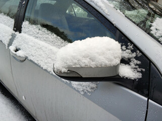Silvered car covered with thick layer of snow at cloudy day light