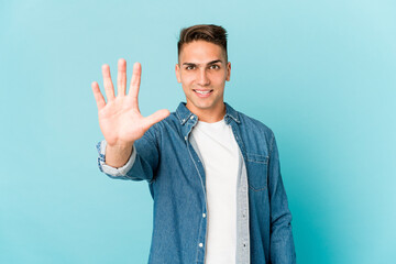Young caucasian handsome man isolated smiling cheerful showing number five with fingers.