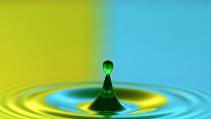 Close-up of a water droplet falling in water in super slow motion, yellow and blue colors - Powered by Adobe