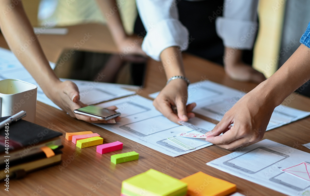 Wall mural designers develop new mobile applications, ui ux design team planning and analyzing mobile applicati