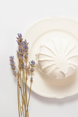 Directly above of Russian traditional soft dessert zefyr souffle served on plate with dried lavender flowers, isolated on light background. Dessert made of apple pectin, egg whites
