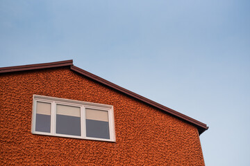 windows on the roof of the red concrete building