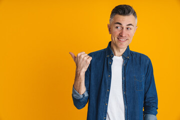 Happy handsome man smiling and pointing finger aside