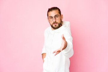 Young man with long hair look stretching hand at camera in greeting gesture.