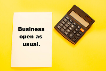 Business open as usual - business text on refreshing background with calculator