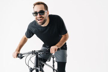 Excited young sportsman in sunglasses riding his bicycle