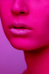 Lips and cheeks. Beautiful east woman's portrait isolated on pink studio background in neon, monochrome. Female brunette model. Concept of human emotions, facial expression, sales, ad, fashion and