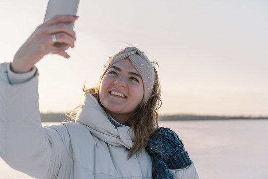 A woman makes a selfie on the phone in the winter. Winter holiday