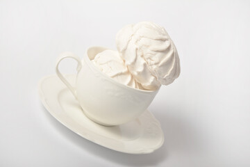 Old cup filled with souffle airy dessert zefir (zephyr) made of organic apple pectin and egg whites, similarly to marshmallow and french meringue. Served on tea plate, isolated on white background
