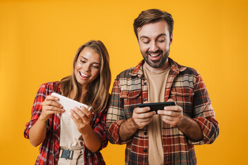Happy charming couple playing video game on mobile phones